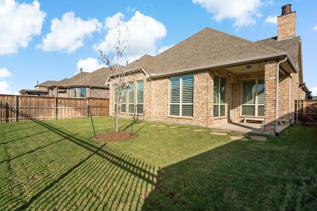 back of property with a yard and a patio area