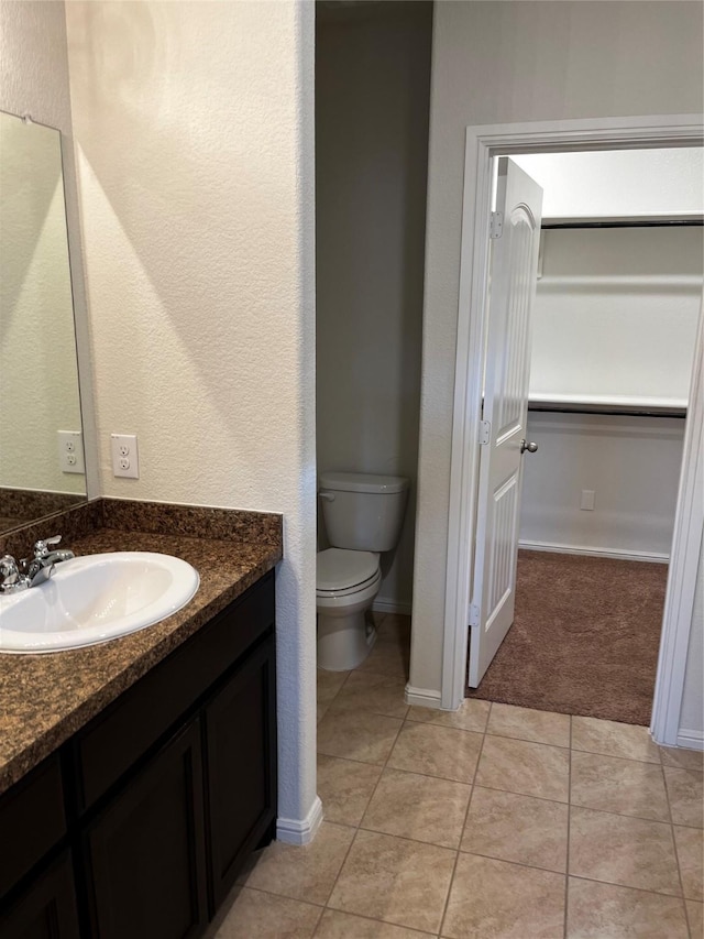 bathroom featuring tile patterned flooring, vanity, and toilet