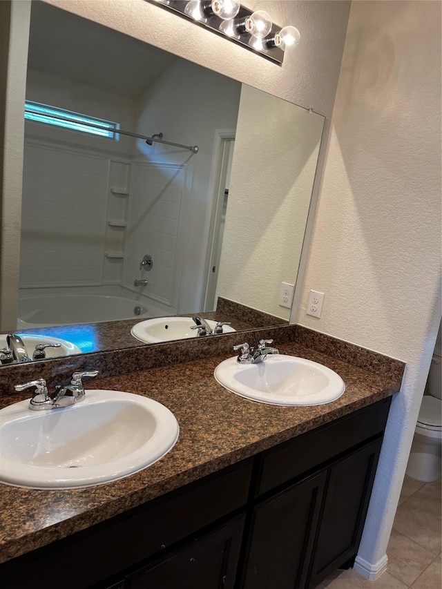 full bathroom with washtub / shower combination, vanity, toilet, and tile patterned flooring