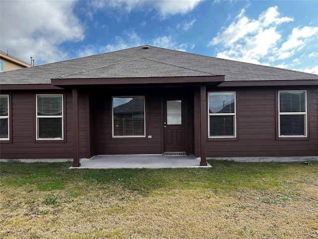 back of property with a yard and a patio area