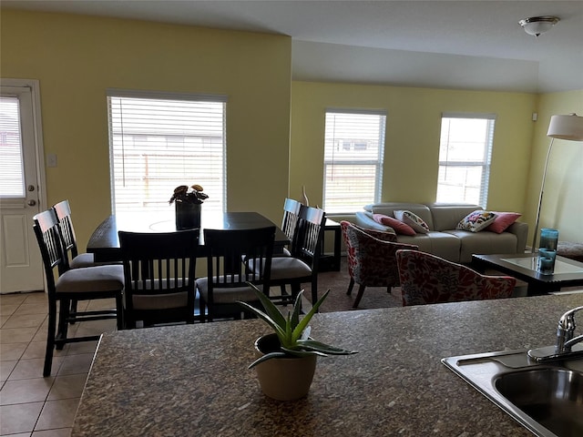 dining area featuring sink and light tile patterned floors