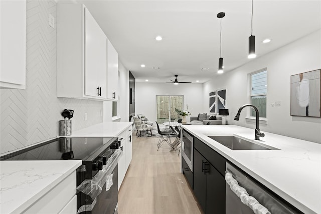 kitchen featuring stainless steel appliances, ceiling fan, sink, decorative light fixtures, and white cabinets