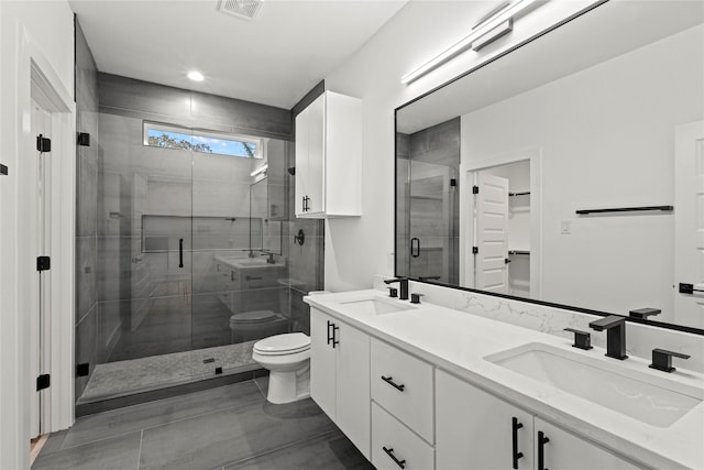 bathroom featuring vanity, a shower with shower door, and toilet