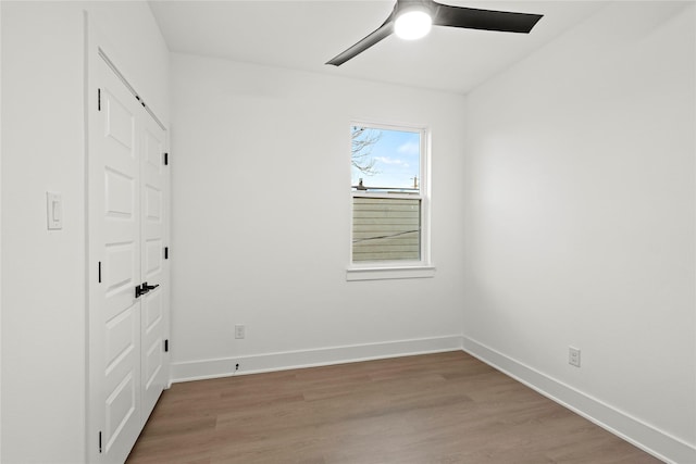 empty room with hardwood / wood-style flooring and ceiling fan