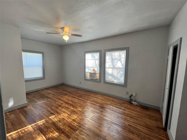 spare room with ceiling fan, cooling unit, a textured ceiling, and dark hardwood / wood-style flooring