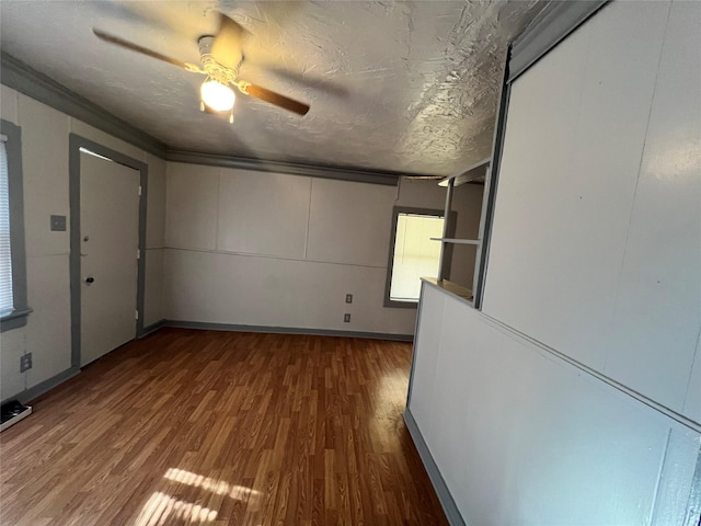 spare room with ceiling fan, hardwood / wood-style flooring, ornamental molding, and a textured ceiling