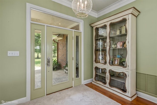 entryway featuring ornamental molding and an inviting chandelier