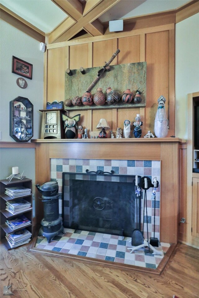 interior details featuring a tile fireplace and wood-type flooring