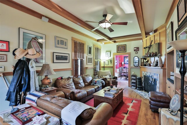 living room with coffered ceiling, wood-type flooring, beamed ceiling, ceiling fan, and a fireplace