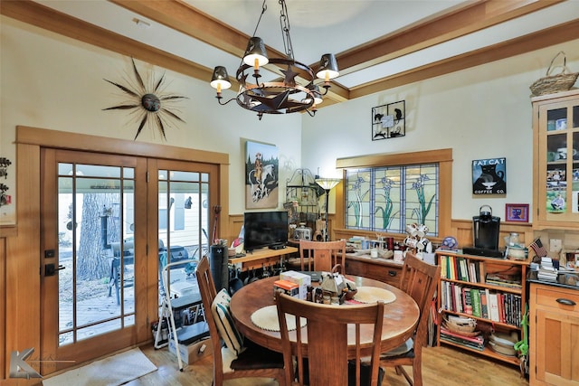 dining space with a notable chandelier, light hardwood / wood-style floors, and beam ceiling