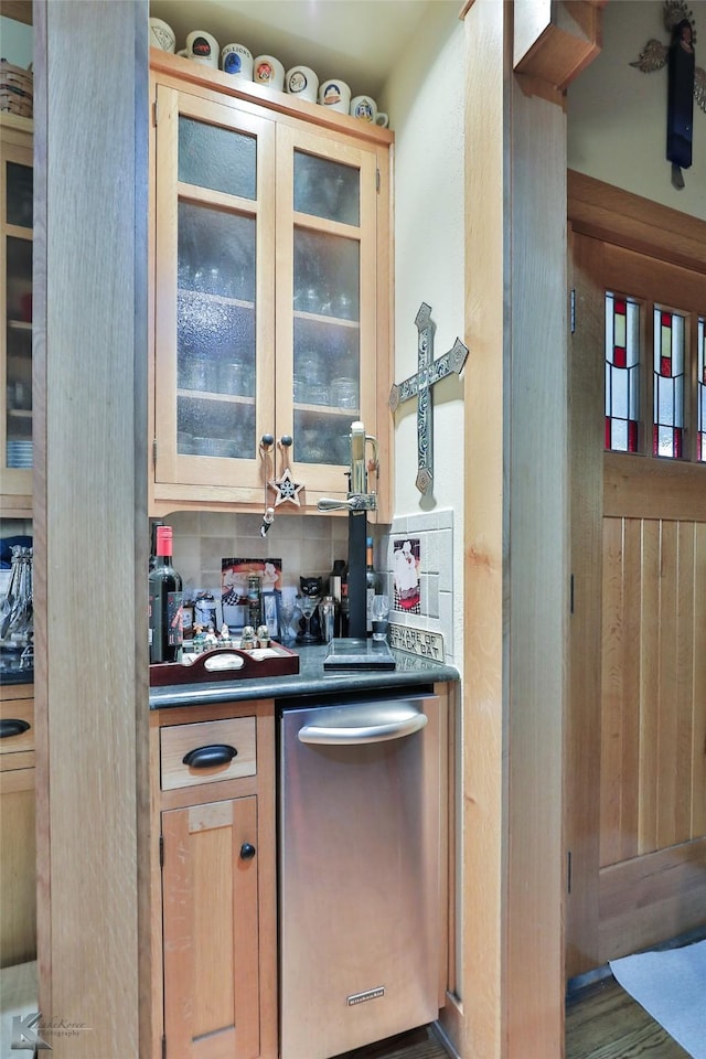 kitchen featuring dark hardwood / wood-style flooring, stainless steel dishwasher, and light brown cabinets