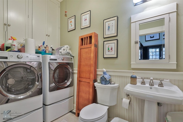 laundry room featuring light tile patterned floors, washer and clothes dryer, and sink