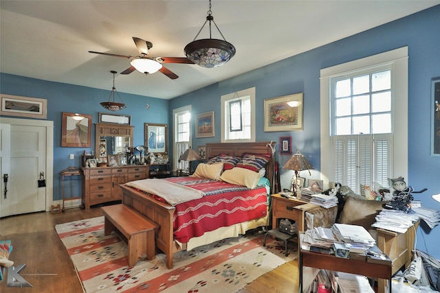 bedroom featuring wood-type flooring, multiple windows, and ceiling fan