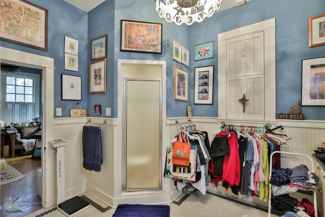 interior space with hardwood / wood-style flooring, a shower with door, and a chandelier