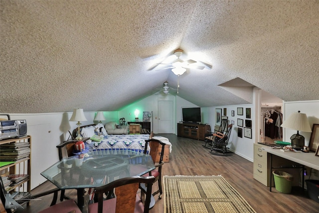 dining space with a textured ceiling, dark hardwood / wood-style floors, vaulted ceiling, and ceiling fan