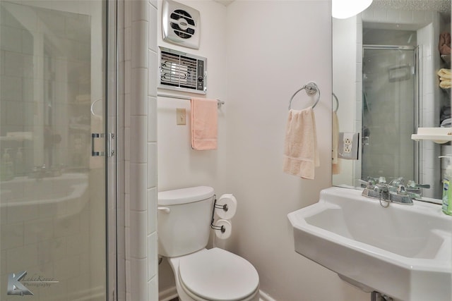 bathroom with toilet, a shower with door, and sink