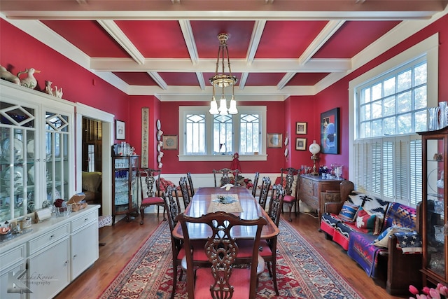 dining room with wood-type flooring, coffered ceiling, and an inviting chandelier