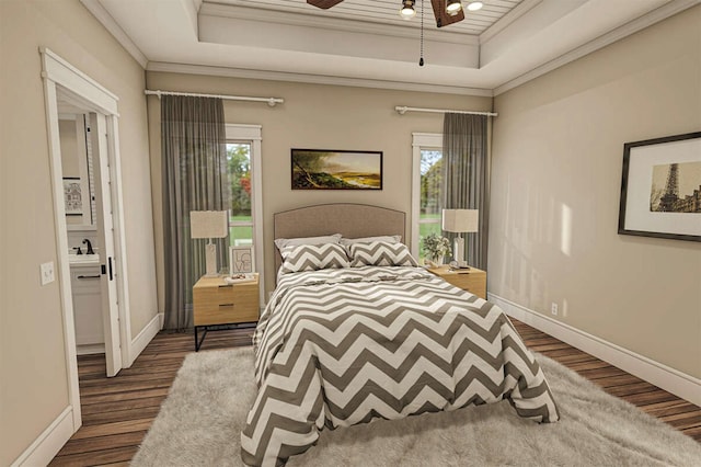 bedroom with a tray ceiling, crown molding, sink, and hardwood / wood-style flooring