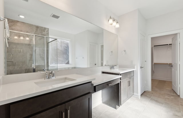 bathroom with vanity, an enclosed shower, and tile patterned floors