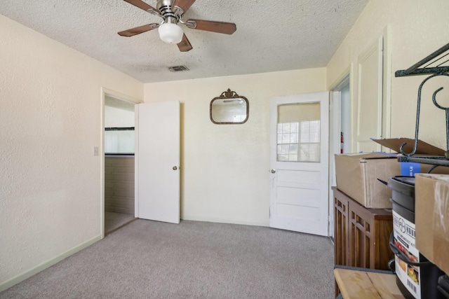 interior space with ceiling fan and a textured ceiling