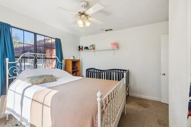 bedroom featuring carpet flooring, a textured ceiling, and ceiling fan