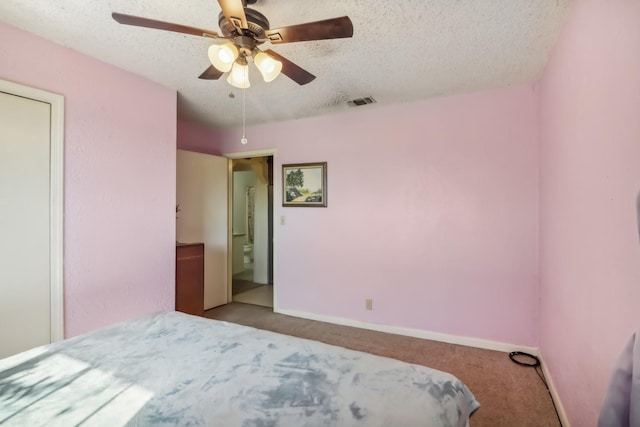 bedroom with ceiling fan, light colored carpet, and a textured ceiling