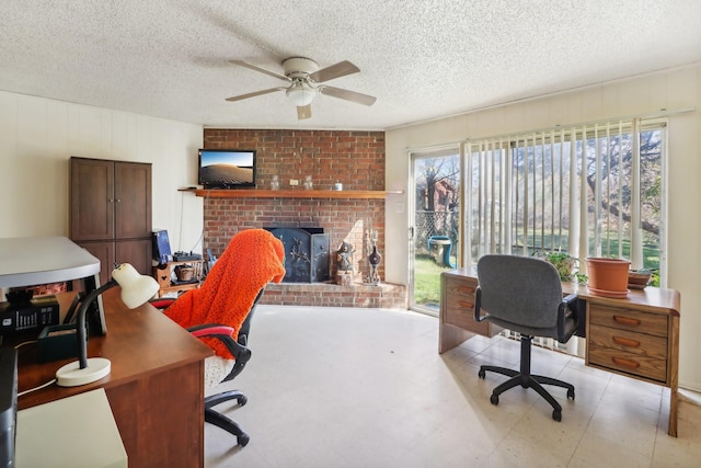 office space featuring a textured ceiling, a brick fireplace, and ceiling fan