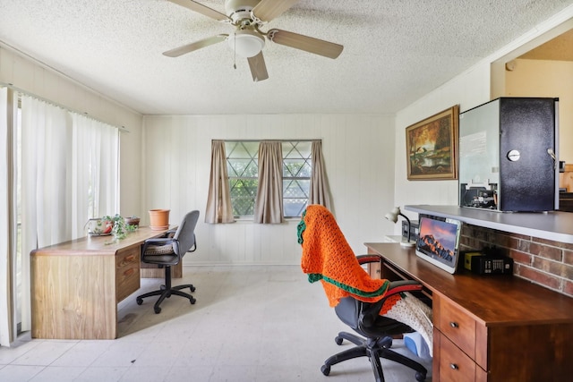 office featuring a textured ceiling, ceiling fan, and wooden walls