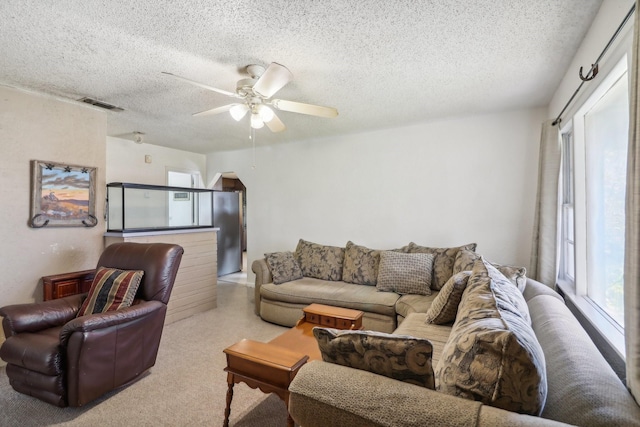 living room featuring ceiling fan and a textured ceiling