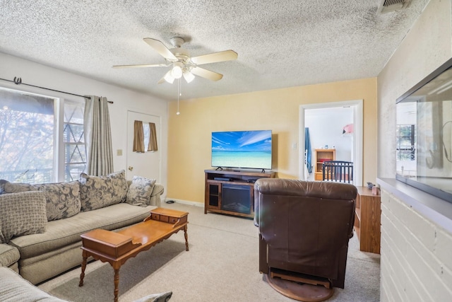 living room featuring a textured ceiling, light colored carpet, and ceiling fan