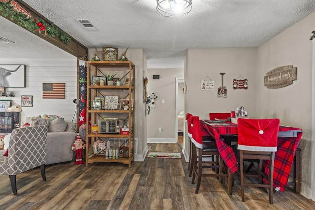 dining space with dark hardwood / wood-style flooring and a textured ceiling