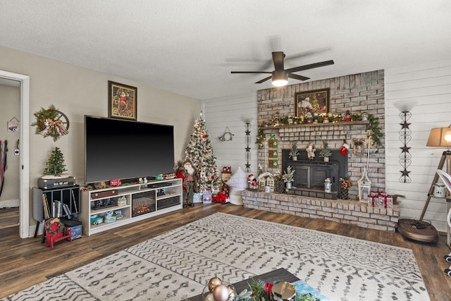 living room with ceiling fan, wood-type flooring, and a textured ceiling