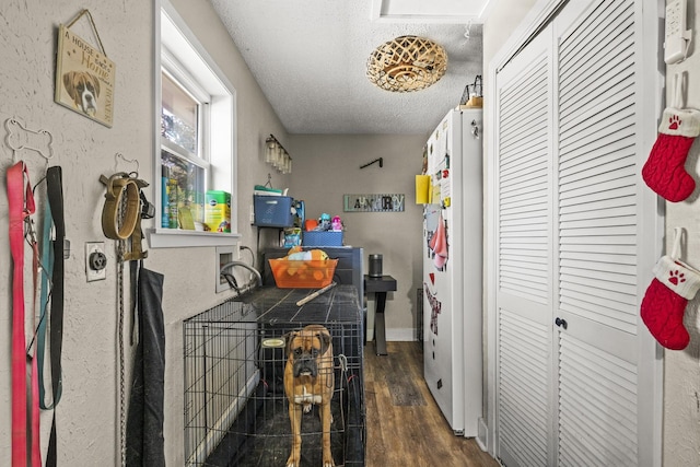 kitchen featuring white fridge, dark wood-type flooring, and a textured ceiling