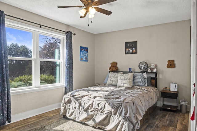 bedroom with dark hardwood / wood-style flooring, ceiling fan, and a textured ceiling