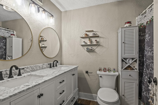 bathroom featuring vanity, a textured ceiling, toilet, and hardwood / wood-style flooring