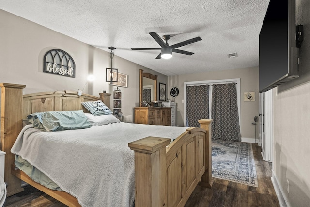 bedroom featuring ceiling fan, dark hardwood / wood-style floors, and a textured ceiling