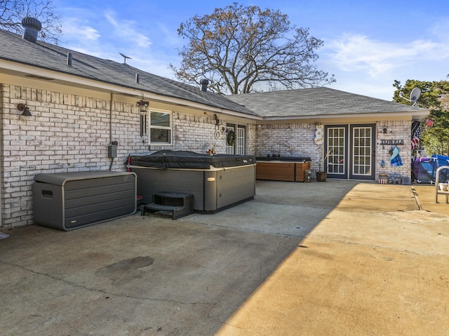 exterior space with a hot tub and a patio