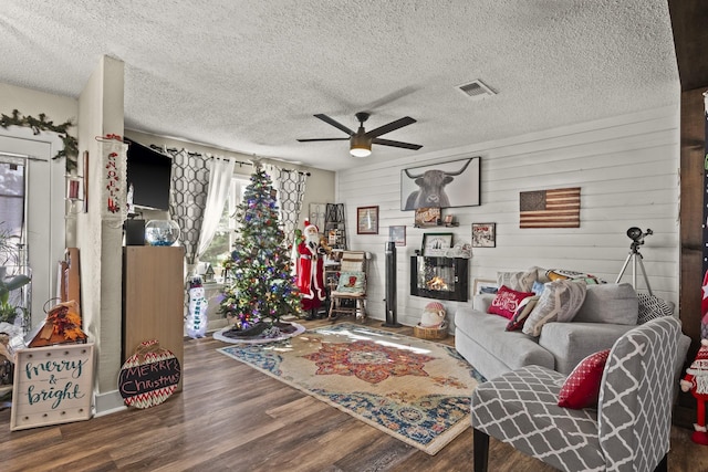 living room featuring hardwood / wood-style flooring, a textured ceiling, and ceiling fan