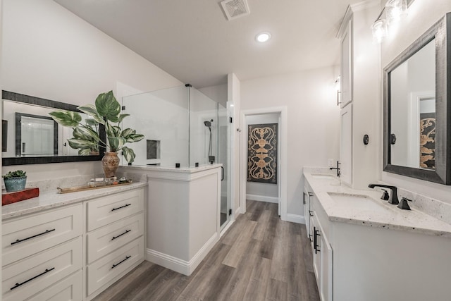 bathroom featuring hardwood / wood-style floors, vanity, and an enclosed shower