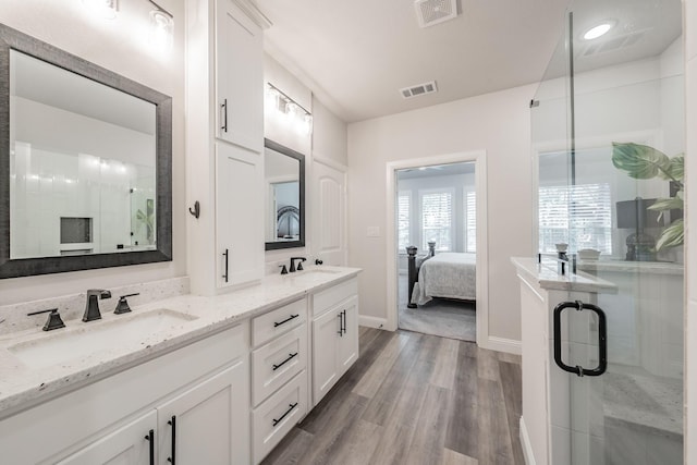 bathroom with vanity, hardwood / wood-style flooring, and a shower with door