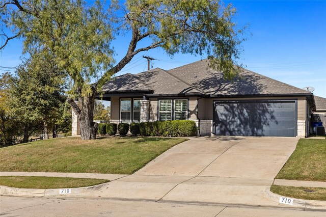 view of front of property with a garage and a front lawn