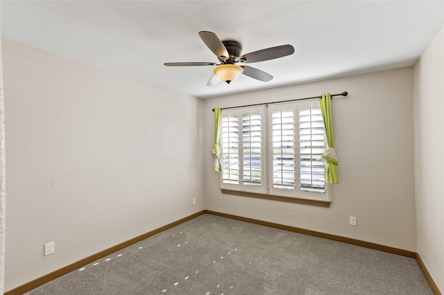 empty room featuring ceiling fan and carpet