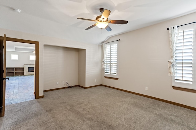 unfurnished bedroom with ceiling fan, lofted ceiling, carpet flooring, and a closet