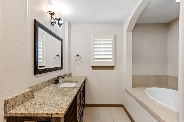 bathroom with vanity, a washtub, and tile patterned floors