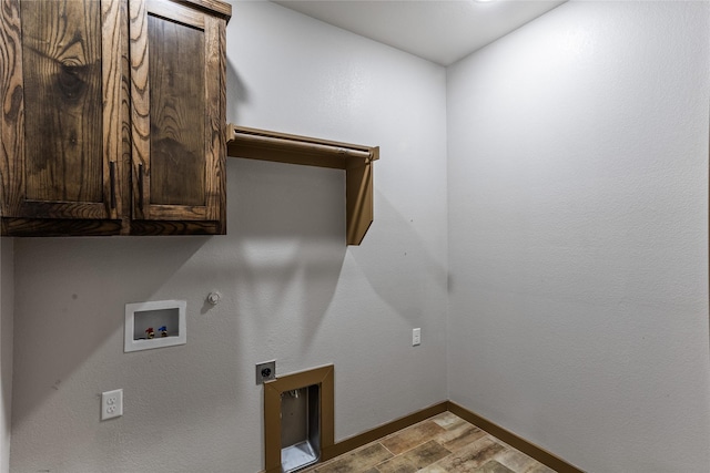 clothes washing area featuring electric dryer hookup, cabinets, washer hookup, hookup for a gas dryer, and light wood-type flooring