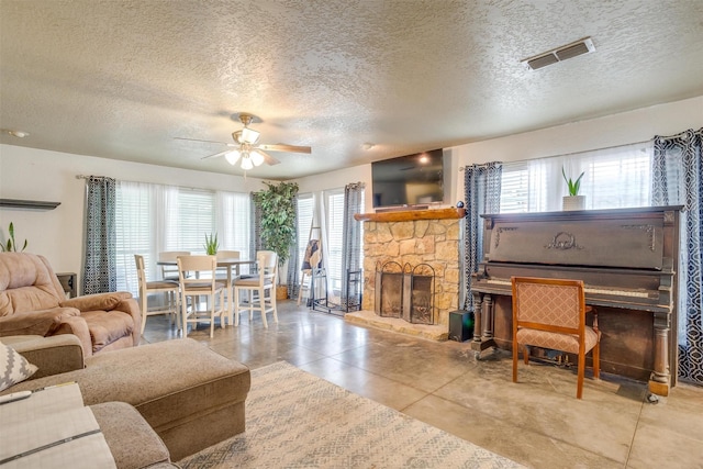 living room featuring plenty of natural light, a fireplace, and a textured ceiling