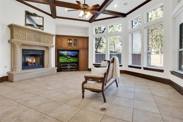 sunroom with beamed ceiling, ceiling fan, and a fireplace