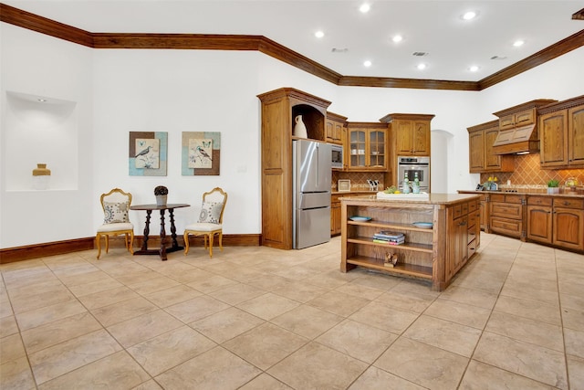 kitchen with appliances with stainless steel finishes, backsplash, a kitchen island, and crown molding