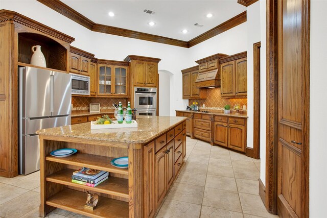 kitchen with backsplash, a center island, ornamental molding, and stainless steel appliances