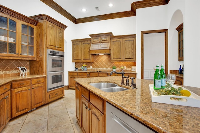 kitchen with crown molding, sink, light tile patterned floors, appliances with stainless steel finishes, and light stone counters